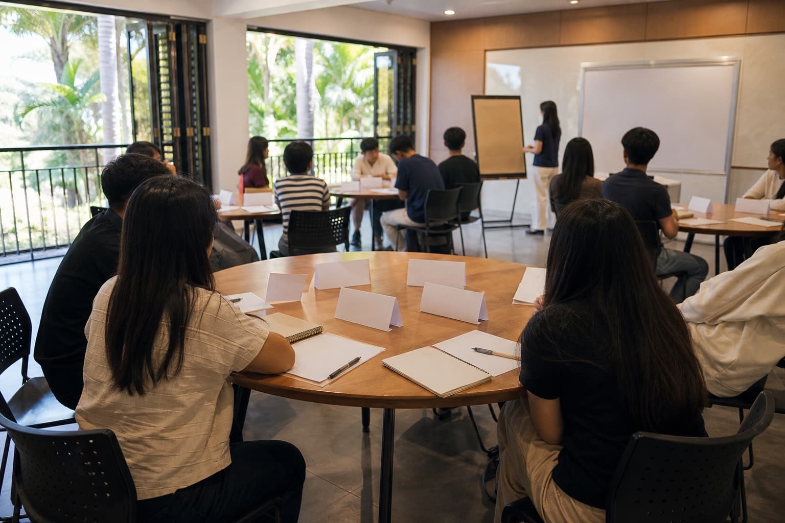Students working together around tables in a workshop space